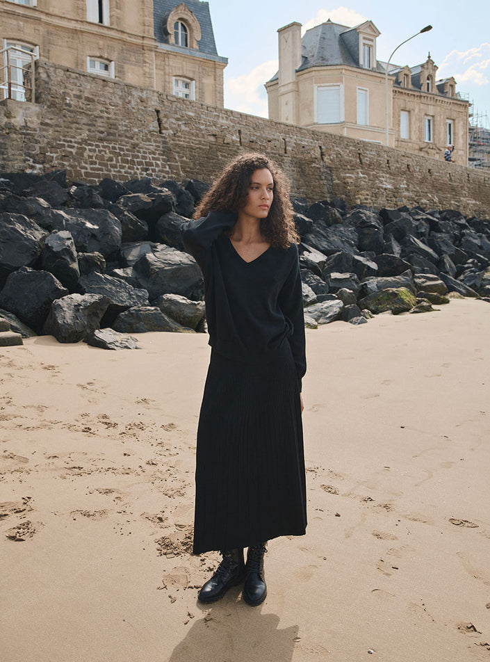 pull aglaé noir porté avec jupe côtelée