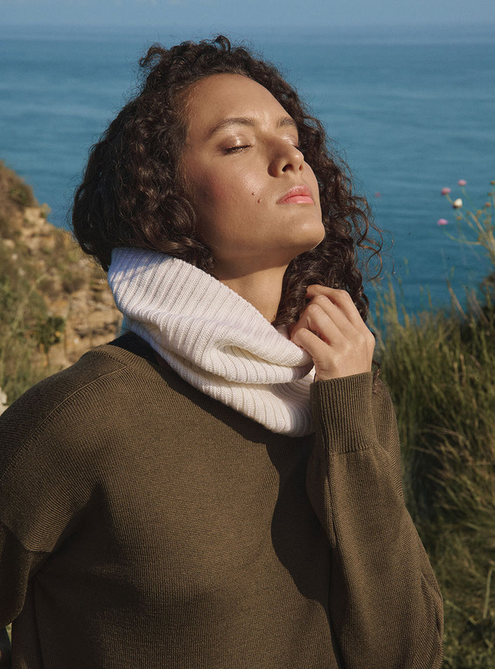 Accessoire blanc naturel en maille porté autour du cou