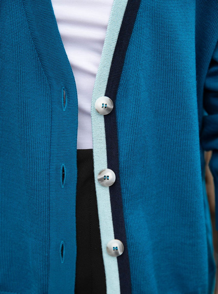 Focus jeu de couleurs et de nuance de bleu sur la patte de boutonnage gilet annabelle bleu paon