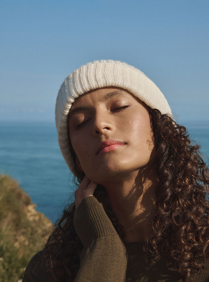 Bonnet ambre blanc naturel avec un pull col v en laine vue de face