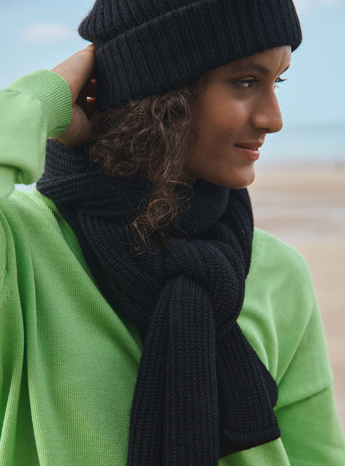 Vue de côté du bonnet ambre noir avec une écharpe noir en mohair